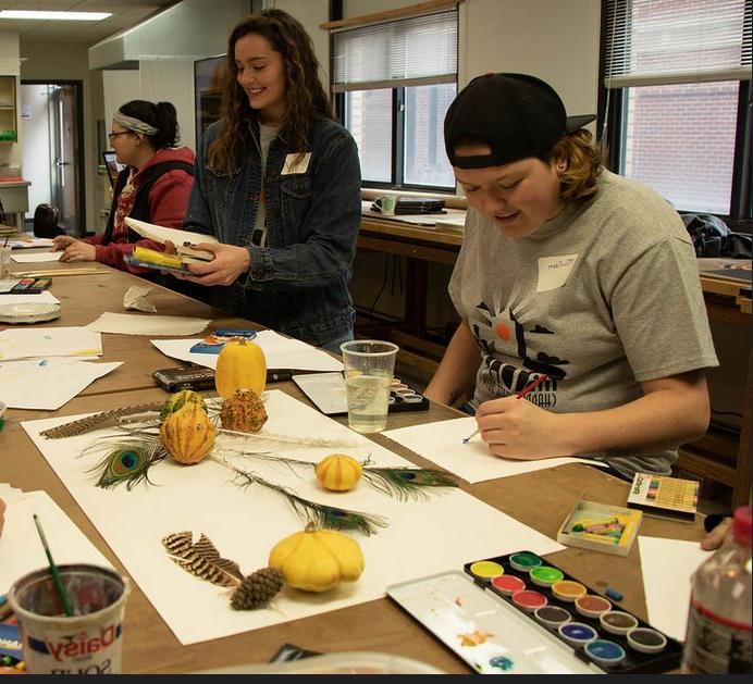 Students painting still life objects
